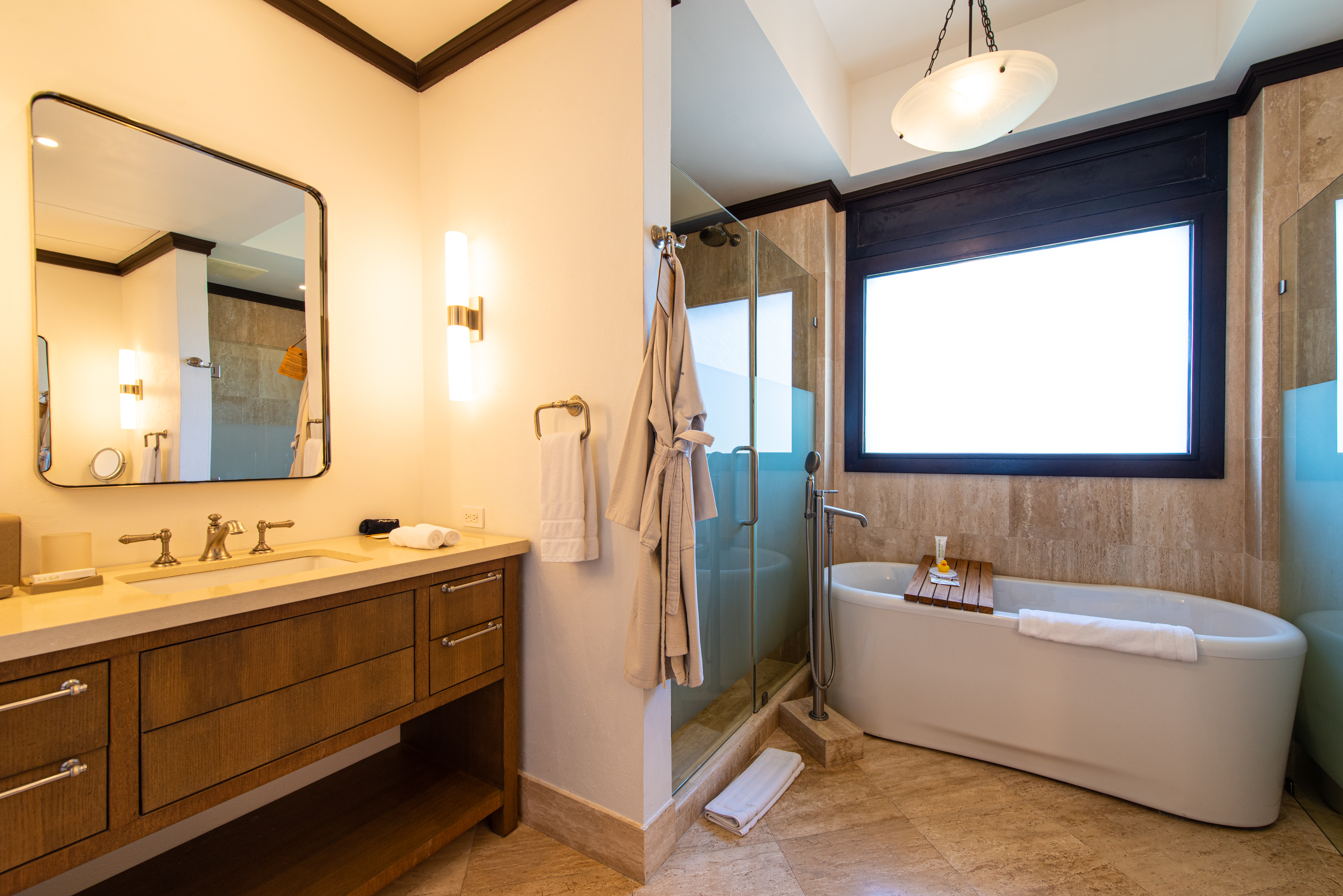 Soaker bathtub, shower, brown vanity and mirror