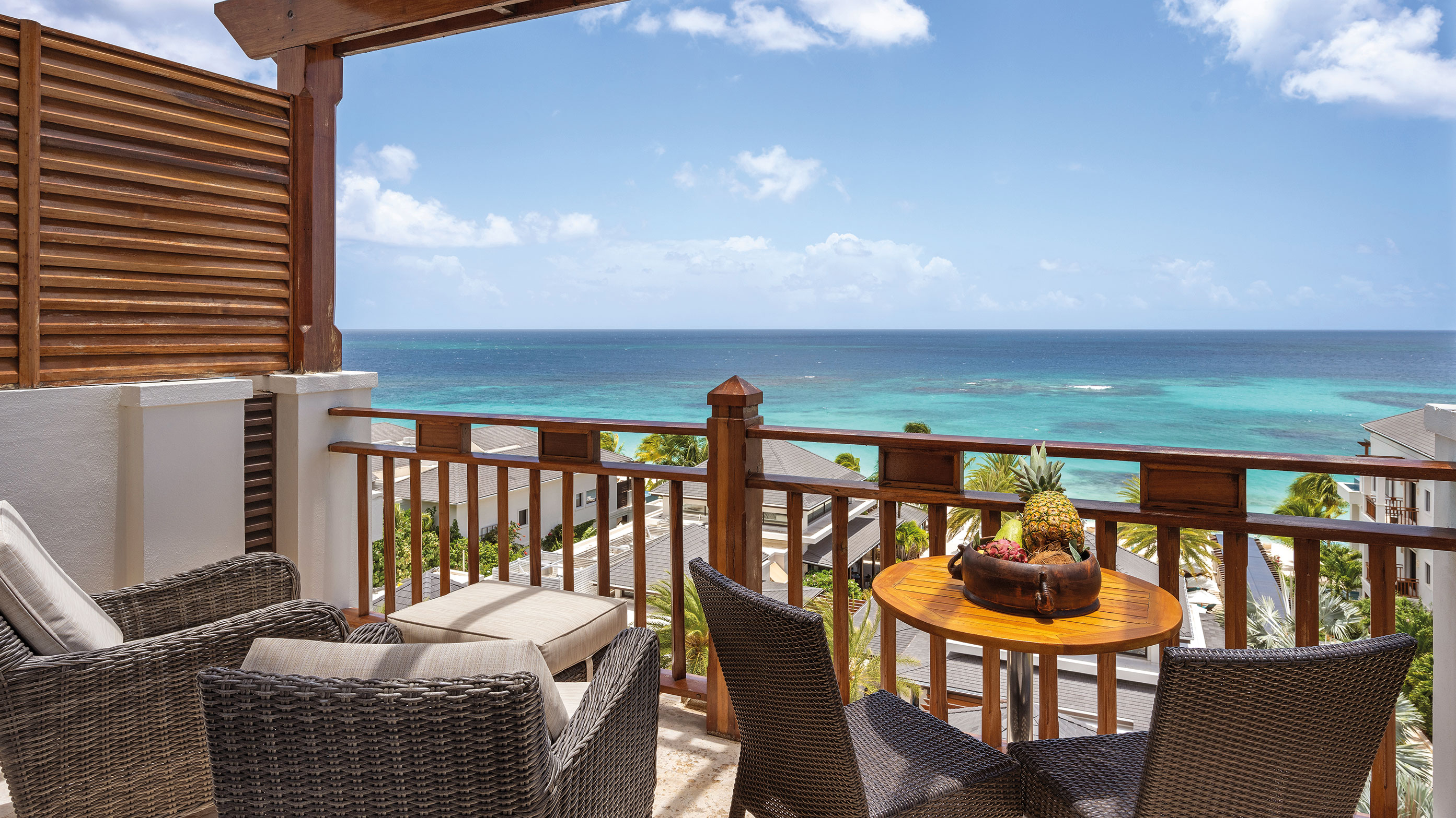 Table and seating area on balcony overlooking ocean