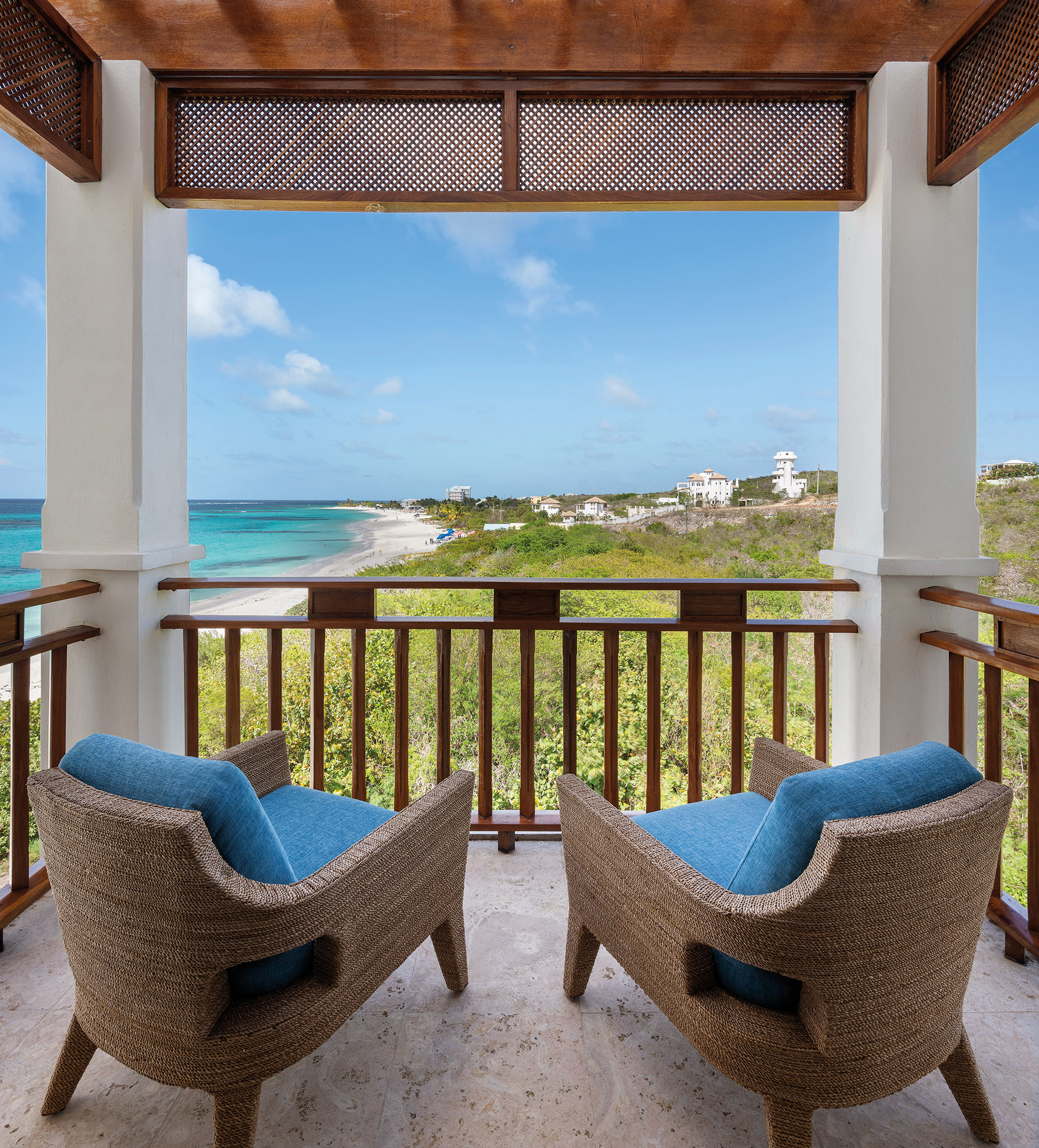 Two chairs on balcony facing ocean