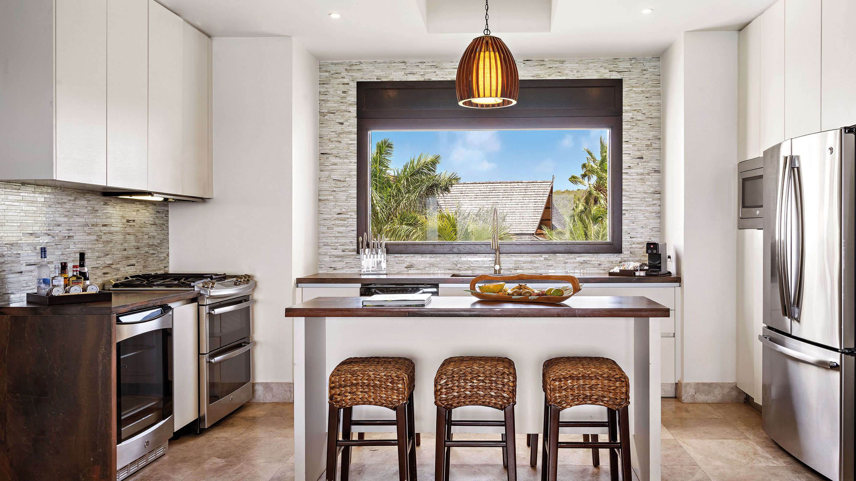 Ilha de cozinha, banquetas, cozinha completa e vista das palmeiras da janela